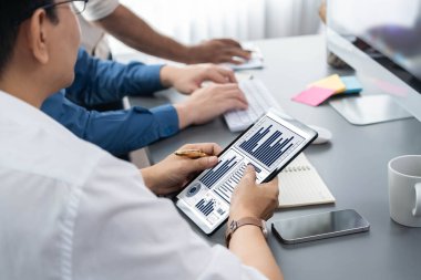 Veri analistleri ofis çalışanlarından oluşan bir ekip, tablet kullanarak finansal, trend ve pazarlama verilerini analiz etmek için iş istihbaratı BI gösterge paneli üzerinde işbirliği yapmaktadır. BI teknolojisi ve veri analizi kavramı. Tedbirli