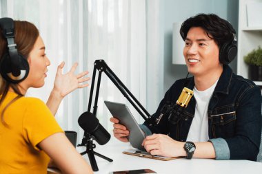 Gülümseyen radyo etkili sunucu elinde tablet, kulaklık takıyor kadın konuşmacı sosyal medya online canlı yayın kanalı ile röportaj yapıyor ve sabah stüdyo kaydında paylaşım linkini paylaşıyor. İnfobahn.