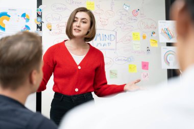 Profesyonel çekici kadın lider, modern iş toplantı odasında beyin fırtınası zihin haritalama istatistikleri ve renkli yapışkan notlar kullanarak yaratıcı pazarlama planını sunuyor. Tertemiz..