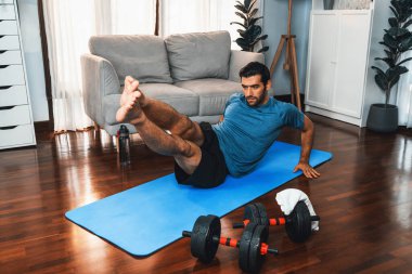 Atletik ve sporcu adam, evde vücut egzersizi yaparken spor ve spor yaşam tarzına uyum sağlamak için spor minderinde çatırdıyor. Gaiety ev egzersizi antrenman konsepti.