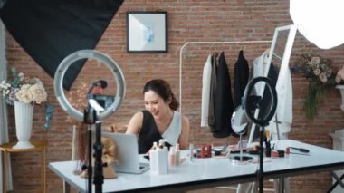 Kadın nüfuzlu kişi sosyal medya ya da blog için canlı yayın yapan video klip eleştirmeni derisini çekiyor. Canlı kozmetik stüdyosu ışıklandırması olan mutlu genç bir kız pazarlama için internet üzerinden yayın yapıyor..