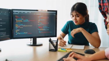 Yavaş çekim arkası yazılım geliştirici mühendisi bilgisayar programlama için birlikte çalışarak hata ayıklama kodunu çözüyor, ofiste monitörde karmaşık algoritmaları çözüyor. Filizlenen