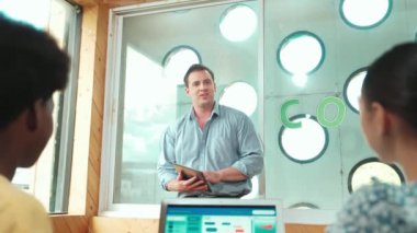 Kodlama ya da yazma programını açıklarken Kafkas öğretmeninin elinde tablet var. Bilgisayar kullanarak birlikte çalışırken melez öğrencilerin mühendislik kodları çalışmalarının arka planı. Öğretim