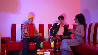 Bir grup break dansçı restoranda oturuyor ve pembe neon ışıklı müzik eşliğinde hareket ediyorlar. Profesyonel hipster dans ediyor ve birlikte otururken enerjik bir hareket sergiliyor. Mutluluk.