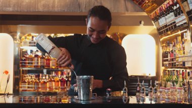 Asyalı barmenin karışık kokteyl likörünü likör karışımına katması, özel reklamı yaratıcı, canlandırıcı, bar lüksünde canlandırıcı bir vitrin haline getiriyor. Vinosity.