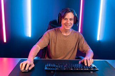 Kazanmak için çevrimiçi oyun oynayan akıllı flama makinesinin sunucu kanalı, neon ışıklı odada seçilen takım yarışması için izleyicilerle birlikte canlı yayında canlı yayında kulaklık takıyor. Bireysel.