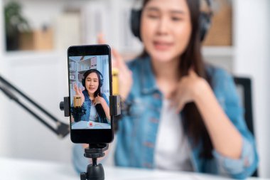 Yaratıcı yayıncı genç ve güzel Asyalı 'nın sunucu kanalındaki seçici odaklı telefon stüdyodaki dinleyiciyle günlük hayatta pazarlamayı veya danışmanı desteklemek için online olarak konuşuyor. Taktik.