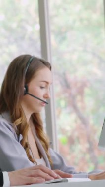 Ofiste çalışan kulaklık takan işadamları uzak müşteri ya da meslektaşlarını desteklemek için çalışıyorlar. Arama merkezi, tele pazarlama, müşteri destek acentesi telefon görüşmesinde hizmet sunar.