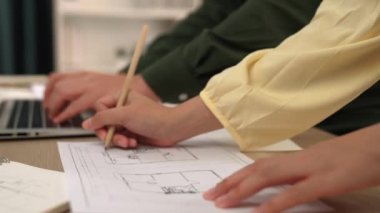 Mimari ve güvenlik mühendisi, modern ofiste doğruluk için mimari belge ve ölçüm aracına dizüstü bilgisayardaki inşaat ayrıntılı planlarını yazar. - Yakın çekim. Tanımlama.