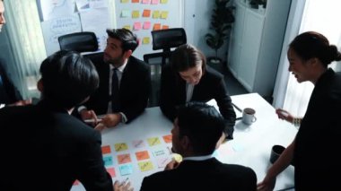Zeki iş adamlarının yukarıdan aşağı görüşü toplantılara katılıyor ve çeşitli iş adamları konferansta yapışkan notlar kullanarak pazarlama fikrini tartışıp beyin fırtınası yaparken finansal planı sunuyor. Müdürlük.