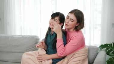 Annesi peri masalı anlatırken, mutlu kız beyaz annelerin kucağında oturuyor. Anne, kızı eve bakıp gülümserken ona sıcak bir şekilde sarılıyor. Aile birlikte vakit geçirir. Pedagoji.