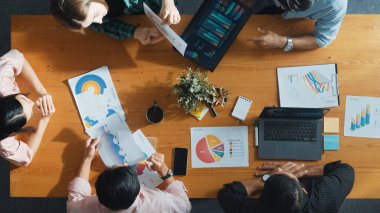 Proje yöneticisinin veri ve mali tabloyu analiz etmek için tablet kullanırken pazarlama ekibinin pazarlama kampanyası ya da toplantı odasında planlama stratejisi üzerinde birlikte çalışmasının en üst görüşü. Cemaat.