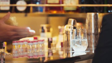 Yakından bir barmen taze gazlı dokuda içki reklamına servis yapıyor. İçki tezgahı lüks barında müşterilere iyi niyet göstergesi olarak sunuyor. Vinosity.
