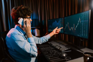 Neon Light Modern Ofis 'te borsa borsası grafiği ile akıllı telefondaki borsacıyla gerçek zamanlı çalışan genç bir tüccar. Dinamik döviz kurunu analiz etme kavramı. Toplayıcı.