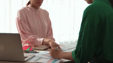 Yavaş çekim iki tasarımcı beyin fırtınası yapıyor ve grafik tasarımı için renk seçiyor ya da istemci renk bozukluklarını tasarımcı bürosundaki kromatik konsültasyonla karşılaştırıyor. Değiştirilmiş
