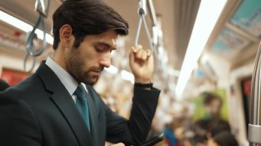 Profesyonel bir iş adamı trende etrafını insanlar sarmışken saate ve telefona bakıyor. Yönetici e-posta kontrolü, bulanık geçmişi olan pazarlama stratejisi planlama. Sevinçli..
