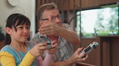 Büyükbaba ve torun birlikte konsol oyunu, eğlence medyası oynuyorlar. Eski kullanım teknolojisi yeni nesil ile iletişim kurar. Nesiller arası uçurum aile bağını güçlendirir. Uyumsuzluk.