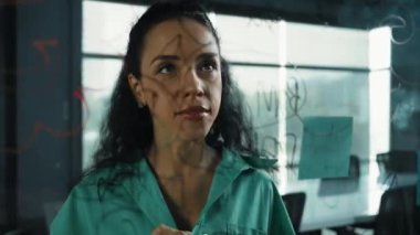 Skills 'in genç ve güzel İspanyol proje yöneticisi pazarlama fikrini düşünüyor. Ofisteki cam tahtada yapışkan notlar kullanarak iş planı yapan profesyonel bir iş kadını. Yönlendirici.