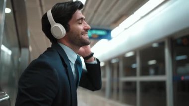 Tren istasyonunda geçmişi bulanık bir şekilde beklerken kulaklıkla müzik dinleyen zeki bir iş adamı. Yetenekli proje yöneticisi cep telefonu tutarken dinlenme sesi dinlemeyi sever. Sevinçli..