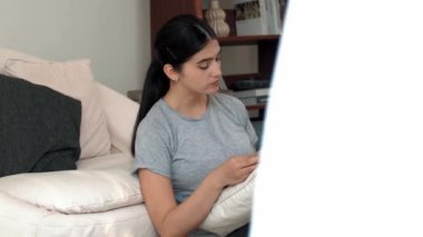 Kanepede oturan bir kadın ders kitabı okuyarak sosyal ve mesleki teknoloji bilgisini artırır ya da akıllı bir anne olmak için çocuk yetiştirir. Hayat boyu öğrenme konsepti. Uyumsuzluk.