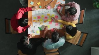 Renkli yapışkan notlarda pazarlama ve planlama stratejisi yazarken insanların yazma ve çalışma tahtası oluşturma konusunda üst düzey bir bakış açısı. Akıllı takım Kanaban tahtasını kullanarak iş performansını yönetir. Cemaat.