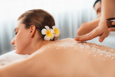 Lüks spa salonlarında sıcak mum ışığında cilt bakımı gören mutlu çift müşterisi. Sağlık kaplıcasında güzellik tedavisiyle tuz temizliği. Sessiz.