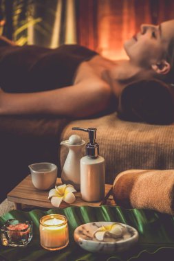 Aromaterapi masajı ambiyansı ya da spa salonu kompozisyon düzeneği bulanık kadınlara odaklı dekor mumları ve spa aksesuarları ile tatil köyü veya otel arka planında keyifli aroma spa masajı yapan. Sessiz.