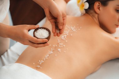 Lüks spa salonlarında sıcak mum ışığında cilt bakımı yaptıran kadın müşteri. Sağlık Spa vücut fırçasında tuz temizleme güzellik tedavisi. Sessiz.