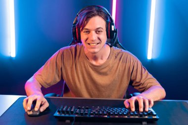 Kazanmak için çevrimiçi oyun oynayan akıllı flama makinesinin sunucu kanalı, neon ışıklı odada seçilen takım yarışması için izleyicilerle birlikte canlı yayında canlı yayında kulaklık takıyor. Bireysel.