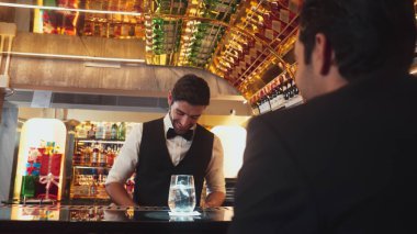 Akıllı barmen, lüks bir tezgahta arkadaşını beklerken limonlu cin kokteyli ikram ediyor. Barmen, canlı gece hayatı parti atmosferinde mükemmel hizmet veriyor. Vinosity.
