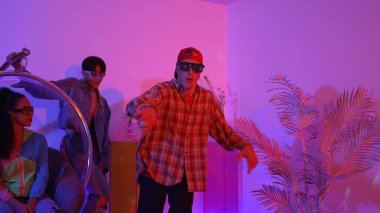 Stüdyoda gündelik kıyafetleri olan çok kültürlü bir arkadaş tezahürat yaparken mutlu hipster break dansları. Profesyonel sokak dansçısı hip hop ritmi ya da neon veya kurşun ışıkla kafiyeli bir şarkı söyler. Mutluluk.