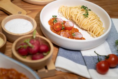 Lezzetli yiyecekler, ev yapımı spagetti, kıymalı domates sosu ve fesleğen fırlatma elementleri, şef masası dekoratif baharatlarla servis ediliyor. Varsayım.