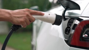 Elle şarj EV şarj prizi tutucusu elektrikli arabaya bağlanıyor, EV araba aküsünü temiz çevre için sıfır CO2 emisyonu ile alternatif ve sürdürülebilir enerjiyle şarj ediyor. Titiz