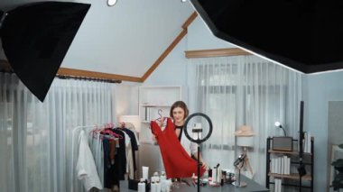 Kadın nüfuzlu kişi video görüntülerini canlı yayınlıyor. Kıyafetler sosyal medyada ya da blogda yer alıyor. Stüdyo ışıklandırmalı mutlu genç kız çevrimiçi pazarlama oturumu yayını için..