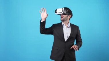 Finansal rapor hologramına bakarken finansal verileri yöneten akıllı bir proje yöneticisi. Yetenekli iş adamı elini hareket ettiriyor ve mali tablolara bakarken mavi arka planda duruyor. Aygıt.