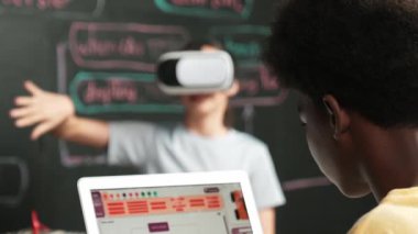 Afrikalı erkek programlama sistemi, beyaz bir kız karatahtanın başında mühendislik kodlarıyla otururken metaverse 'e giriyor. Liseli kız STEM teknolojisinde VR ya da kulaklık takıyor. Öğretim