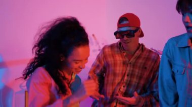 Profesyonel break dansçı neon ışıkla sokak dansı yapar ve pratik yapar. Kafkasyalı adam enerjik hareketler sergilerken mutlu bir takım hip hop müziğine geçiyor. Mutluluk.