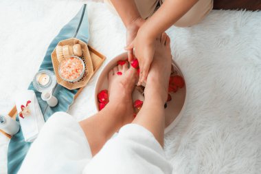 Kadınlar lüks spa salonlarında keyifli ayak masajlarına devam ederken, masör de hafif gün ışığı atmosferinde refleksoloji terapisi veya otel ayak spa 'sında. Sessiz.