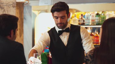 Zeki, gülümseyen barmen lüks bir barda buzlu içecekler hazırlarken aynı zamanda canlı, aydınlık atmosfer barında ve restoranda VIP müşterilerle canlı sohbetler yapıyor. Vinosity.