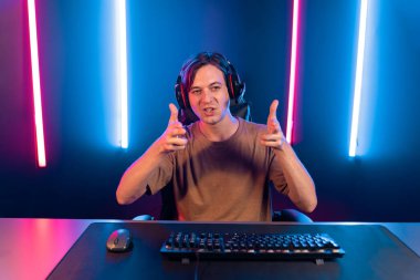 Kazanmak için çevrimiçi oyun oynayan akıllı flama makinesinin sunucu kanalı, neon ışıklı odada seçilen takım yarışması için izleyicilerle birlikte canlı yayında canlı yayında kulaklık takıyor. Bireysel.