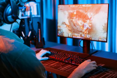 Savaş arenasında çoklu oyunlar takımıyla Moba 'da savaşan genç oyun flamasının sunucu kanalı, neon dijital ışık modern odasındaki arka görüntü ile bilgisayar monitöründe kulaklık takıyor. Toplayıcı.