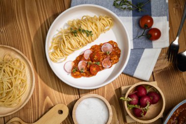 Lezzetli yiyecekler, ev yapımı spagetti, kıymalı domates sosu ve fesleğen fırlatma elementleri, şef masası dekoratif baharatlarla servis ediliyor. Varsayım.