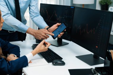 Kâr değeri değeri oranı online web sitesi uygulamasını ev ofisinde analiz etmek için notlar yazan kadınlara telefonda dinamik borsa verilerini gösteren bir işadamı eli kesilmiş. İnfobahn.