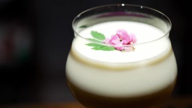 Tutkulu meyve suyu bardağında dönüşümlü, özel, ferahlatıcı, pembe çiçekle süslenmiş, lüks gece klübünde gece hayatı karışımı sergilenen bir içecek. Vinosity.