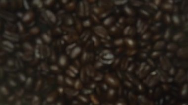 Kahve çekirdeklerinin yukarıdan aşağıya, kamera efektli görüntüsü. Tasarım ve baskı için stüdyo fotoğrafçılığı. Makro kahve çekirdeği, kahverengi renkli ve döner kameralı. Konsepti kapat. Pabulum.