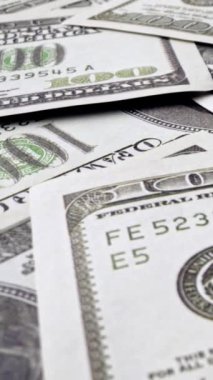 Ofis masasında 100 dolarlık kağıt para yığını. Maliye ve para ödemesi kavramı.