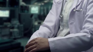 Doktorun oturduğu ve elinde tıbbi çapraz hologramı ve bulanık geçmişi olan hastahaneyi gösteren bir fotoğraf. Pratisyen hekim teknolojik yenilikleri kontrol edip kullanıyor. İyileştirici.