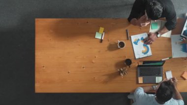 Çeşitli takımlar tabletteki fikirleri ya da finansal tabletleri paylaşırken yönetici patronla telefonla konuşuyor. İnsan telefonla konuşurken beyin fırtınası yapan ve planlarını paylaşan farklı insanların üst düzey görüntüsü. Cemaat.