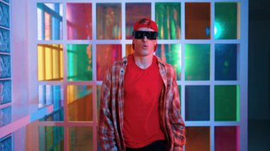 Serbest stil tişört giyerken sokak müziği çalan mutlu hipster. Gece kulübünde neon ışıkla dururken çekici break dansçı dans ve hareketli hareketler yapıyor. Mutluluk.