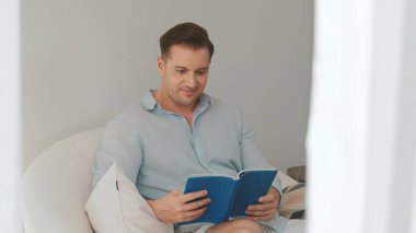 Kanepede oturan orta yaşlı bir adam, sosyal ve teknolojik mesleki gelişmeler hakkında ders kitabı okur ya da çocukları iyi bir yetişkin baba olmak için yetiştirir. Hayat boyu öğrenme konsepti. Uyumsuzluk.